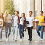 Diverse students walking together in campus, having break after classes